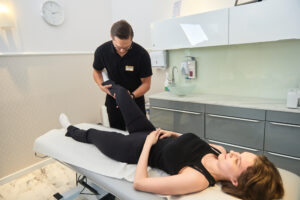 Zdjęcie przedstawia pacjentkę i terapeutę w trakcie zabiegu bFizjoterapia i rehabilitacja z uśmiechem